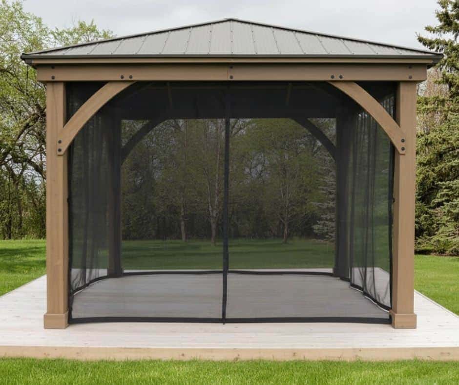 Mosquito Mesh Kit for Costco 12ft x 12ft Mocha Gazebo Costco Accessories Premium Cedar Gazebos with Aluminium Roofs Freestanding gazebo with a metal roof and zippered mesh screen walls, set on a wooden platform in a grassy outdoor area with trees in the background.