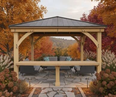 Wooden gazebo with outdoor seating surrounded by colorful autumn trees