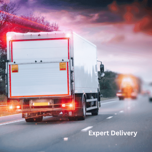 White delivery truck driving on highway at dusk with dramatic sky and illuminated rear lights